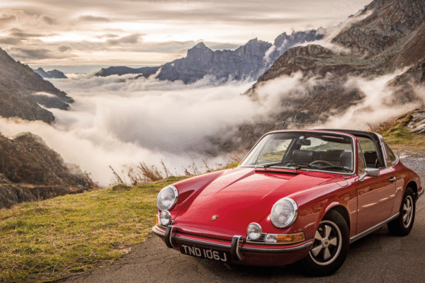Classic Porsche 911 parked in front of mountains