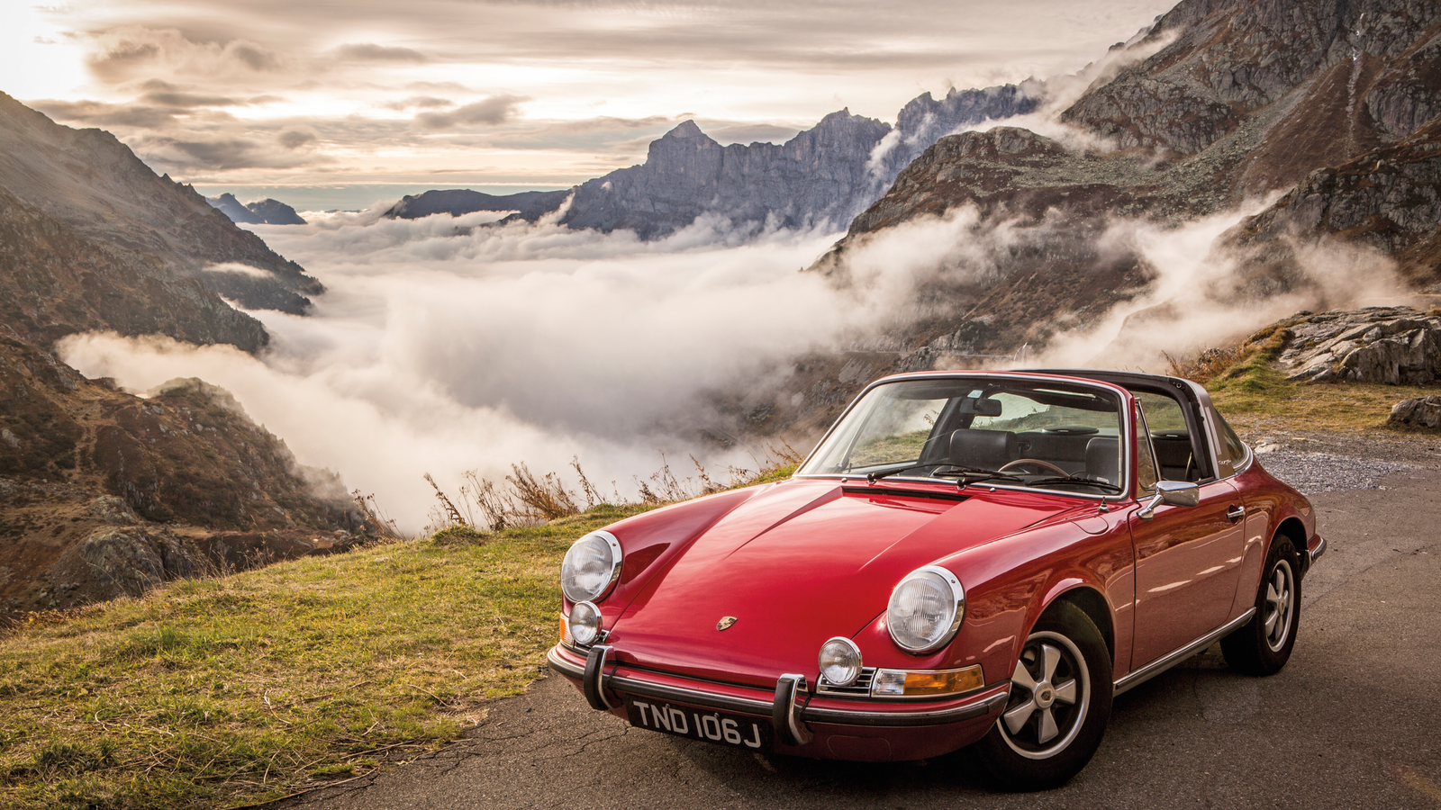 Classic Porsche 911 parked in front of mountains